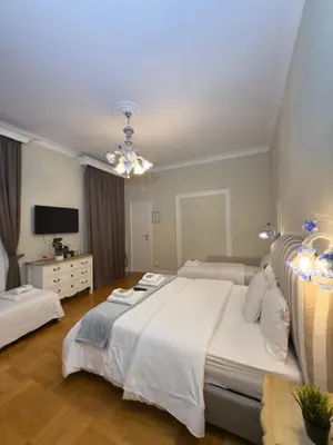 a large bedroom with two beds and a television at Rome Piazza di Spagna Guesthouse in Rome