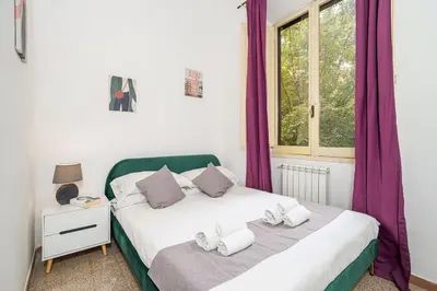two beds in a bedroom with purple curtains at Mazzini 38 in Rome