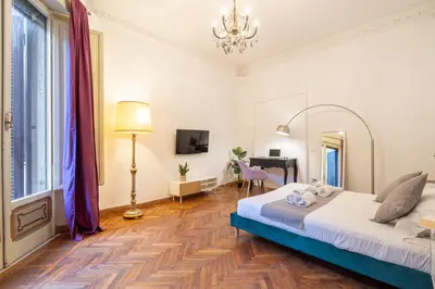a bedroom with a bed and a desk and a mirror at Mazzini 38 in Rome