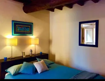 a bedroom with a bed with blue sheets and two lamps at Roman heritage- Pantheon- up to 6 guests in Rome