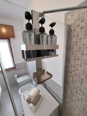 a bathroom with a sink and four glass bottles at Loft Tranquillo e Comodo, Vicino Metro e Vaticano in Rome