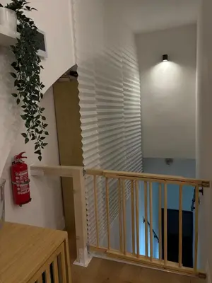 a stairway with a wooden railing and a window at Ilia12 home in Rome