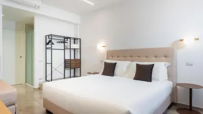 a bedroom with a large white bed and a table at Aura Vatican Suite in Rome