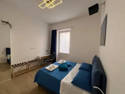 a bedroom with a blue bed and a window at Trastevere ON in Rome
