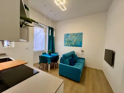 a living room with a blue couch and a table at Trastevere ON in Rome