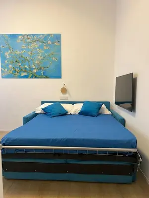 a bedroom with a blue bed with a painting on the wall at Trastevere ON in Rome