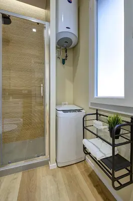 a bathroom with a washer and dryer next to a window at Silver Loft San Giovanni in Rome
