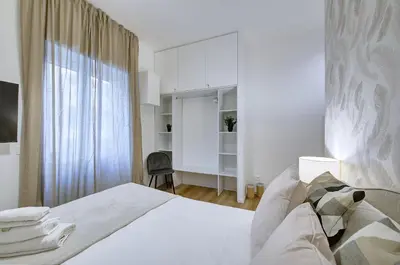 a white bedroom with a bed and a window at Silver Loft San Giovanni in Rome