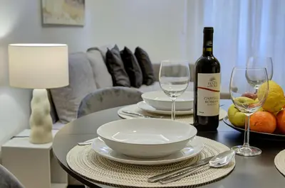 a table with a bottle of wine and two glasses at Silver Loft San Giovanni in Rome