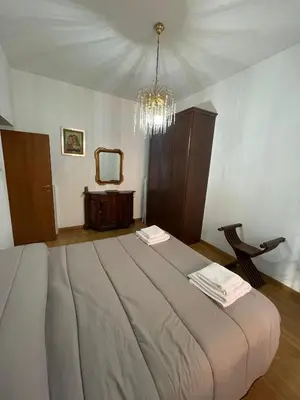 a bedroom with a large bed with a chandelier at Rachel house in Rome