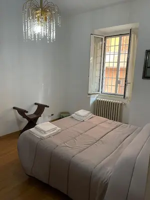 a bedroom with a large bed and a chandelier at Rachel house in Rome