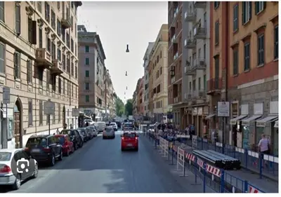 a red car driving down a city street with buildings at Paradise Vatican Home in Rome