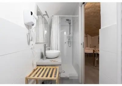 a white bathroom with a sink and a bench at Paradise Vatican Home in Rome