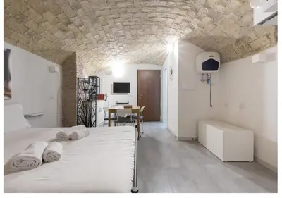a bedroom with a white bed and a table at Paradise Vatican Home in Rome
