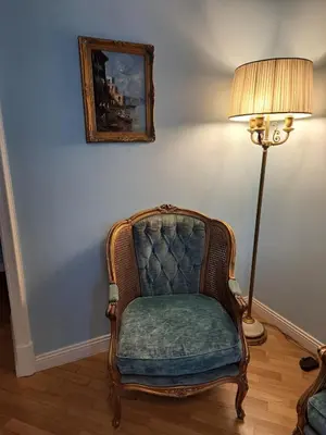 a chair in a room with a lamp and a painting at In the district of Dolce Vita di Fellini in Rome