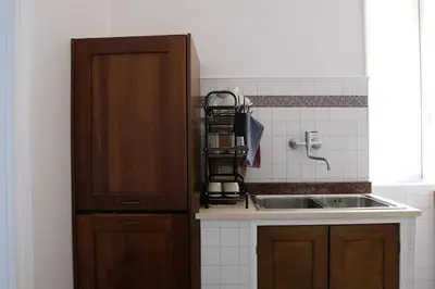 a kitchen with a sink and a wooden cabinet at In the district of Dolce Vita di Fellini in Rome
