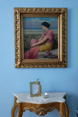 a painting of a woman sitting on a table at In the district of Dolce Vita di Fellini in Rome
