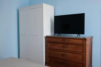 a bedroom with a dresser with a television on it at In the district of Dolce Vita di Fellini in Rome