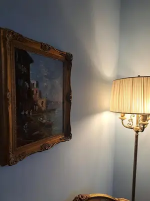a painting hanging on a wall next to a lamp at In the district of Dolce Vita di Fellini in Rome