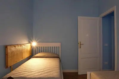 a bedroom with a bed with a headboard and a door at In the district of Dolce Vita di Fellini in Rome