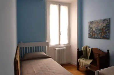 a bedroom with a bed and a window and a chair at In the district of Dolce Vita di Fellini in Rome