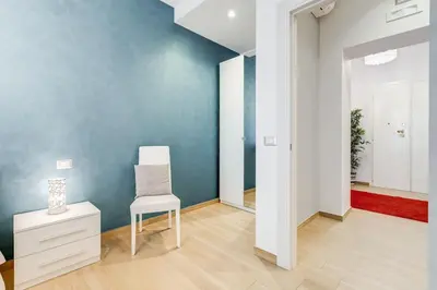 a white chair in a room with a blue wall at Vatican Brothers in Rome