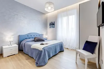 a bedroom with a blue bed and a chair at Vatican Brothers in Rome