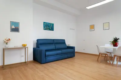 a blue couch in a living room with a table at Studio Piramide in Rome