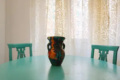 a vase sitting on a table with two chairs at A Casa di Adriana in Rome