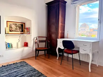 a desk and two chairs in a room with a window at Caesar's Nest in Rome