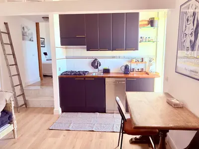 a kitchen with black cabinets and a table and a dining room at Caesar's Nest in Rome