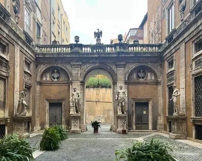 an entrance to a building with an arch with statues at Caesar's Nest in Rome