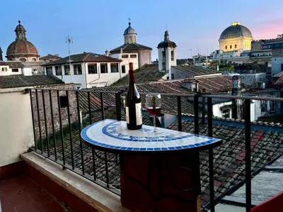 a bottle of wine and a glass on a table on a balcony at Caesar's Nest in Rome