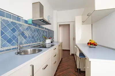 a kitchen with a sink and blue tiles on the wall at A casa di Chloe - Ponte Milvio in Rome