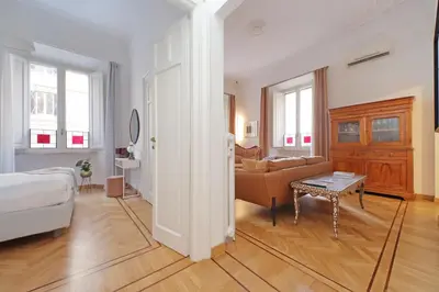 a bedroom with a bed and a living room with a couch at TreasureRome Adriana Charme 4BR in Rome