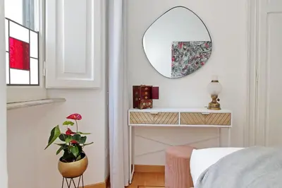 a bedroom with a mirror and a potted plant at TreasureRome Adriana Charme 4BR in Rome
