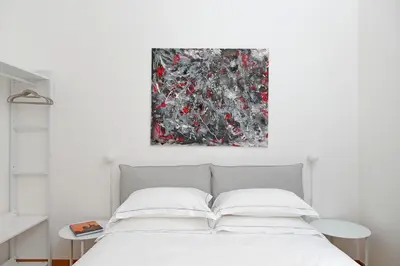 a bedroom with a bed with a painting above it at TreasureRome Adriana Charme 4BR in Rome