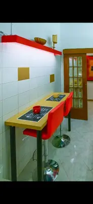 a kitchen with a table with two red stools at Mamma ROMA ART in Rome