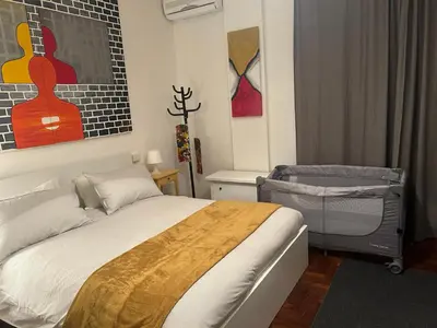 a bedroom with a bed and a chair and paintings at Mamma ROMA ART in Rome