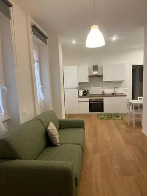 a living room with a green couch and a kitchen at Charlie Apartment 1C in Rome