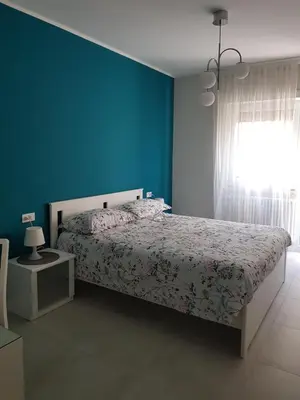 a bedroom with a bed with blue walls and a window at Nuovissimo appartamento zona Vaticano Aurelio in Rome