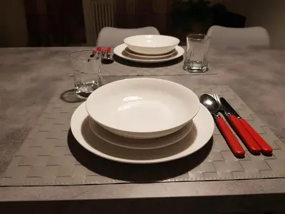 a table with white plates and silverware on a table at Nuovissimo appartamento zona Vaticano Aurelio in Rome