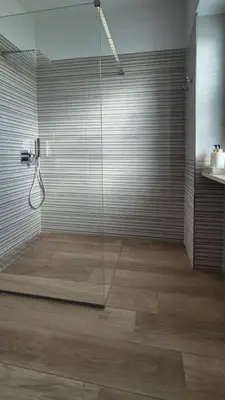 a bathroom with a shower with a glass wall at Nuovissimo appartamento zona Vaticano Aurelio in Rome