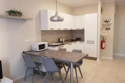 a kitchen with a table with chairs and a microwave at Nuovissimo appartamento zona Vaticano Aurelio in Rome