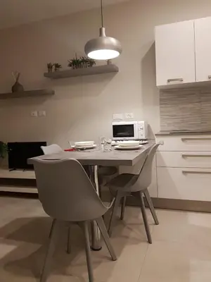 a kitchen with a table with chairs and a microwave at Nuovissimo appartamento zona Vaticano Aurelio in Rome