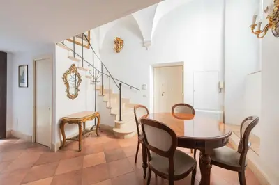 a bedroom with a large white bed and a flat screen tv at Beatrix Apartment in Trastevere by Nosdom Properties in Rome