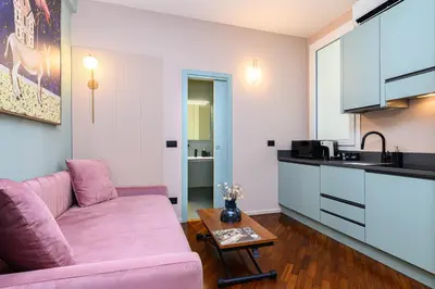 a living room with a pink couch and a kitchen at Casina Doria Pamphili in Rome