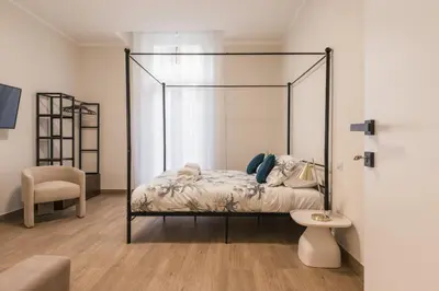 a bedroom with a canopy bed and a chair at Appartamento fino a 17 persone in centro a 17 minuti a piedi da Piazza di Spagna in Rome
