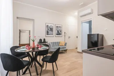 a dining room and living room with a table and chairs at Appartamento fino a 17 persone in centro a 17 minuti a piedi da Piazza di Spagna in Rome