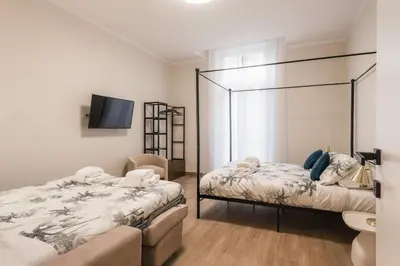 a bedroom with two beds and a tv in it at Appartamento fino a 17 persone in centro a 17 minuti a piedi da Piazza di Spagna in Rome